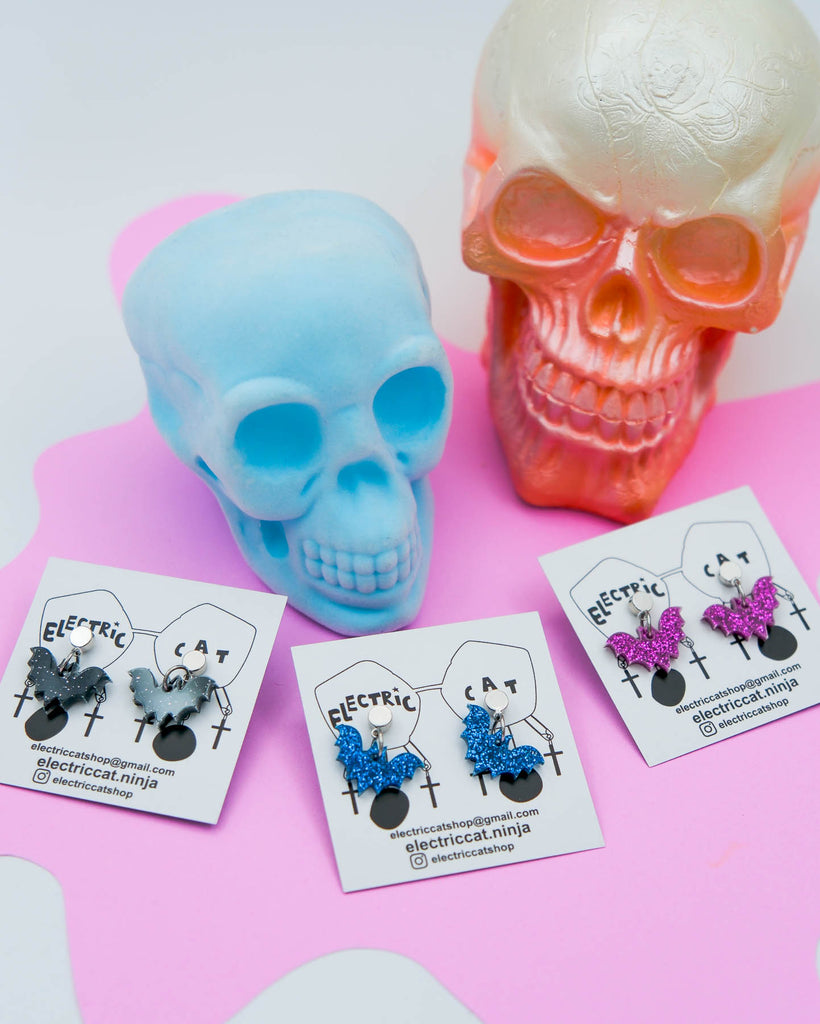 Black glitter, blue glitter, and purple glitter acrylic bat post earrings by electric cat