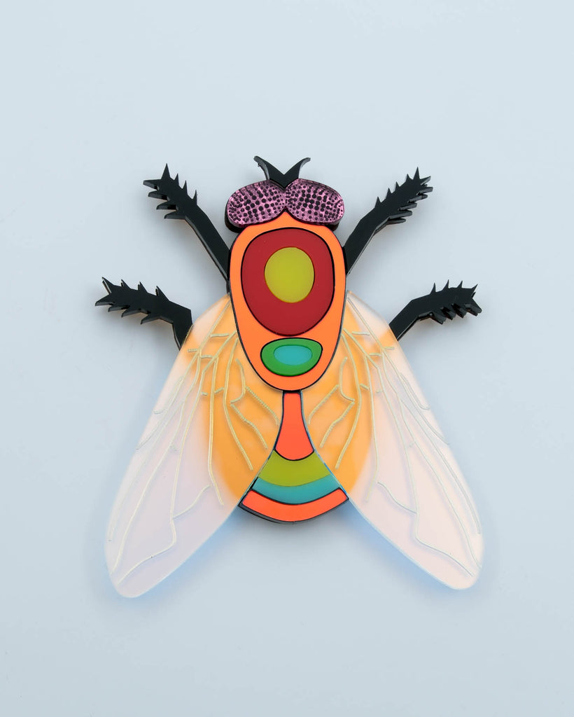Handmade acrylic fly art piece featuring iridescent wings, black legs, and layered colorful body with pink mirrored eyes, crafted by Electric Cat.