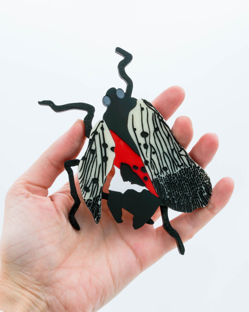Handmade laser-cut acrylic and wood art piece showing a squashed spotted lanternfly with red and black markings, designed by Electric Cat.