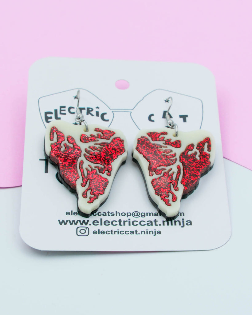 Red glitter and ivory acrylic steak earrings shown on branded Electric Cat card, handmade statement jewelry.