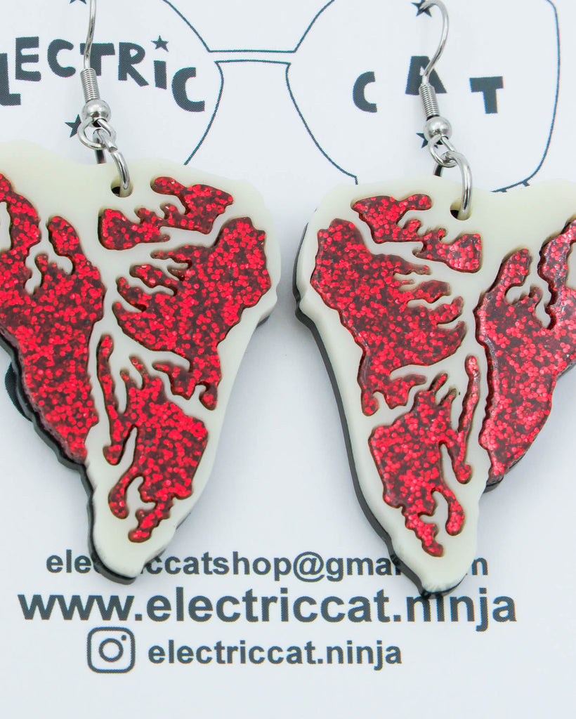 Red glitter and ivory acrylic steak earrings shown on branded Electric Cat card, handmade statement jewelry.