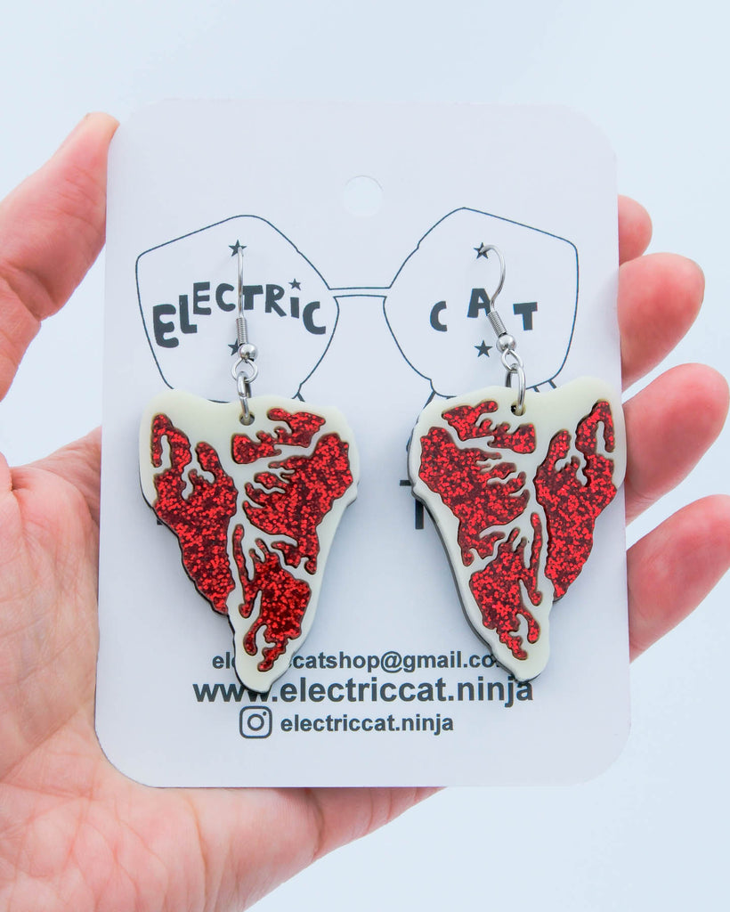 Red glitter and ivory acrylic steak earrings shown on branded Electric Cat card, handmade statement jewelry.
