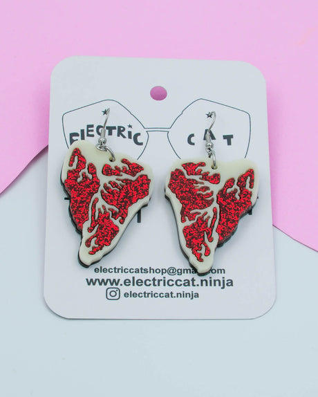 Red glitter and ivory acrylic steak earrings shown on branded Electric Cat card, handmade statement jewelry.
