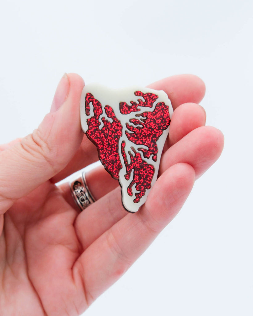 Handmade acrylic steak magnet featuring red glitter details and ivory base, crafted by Electric Cat.