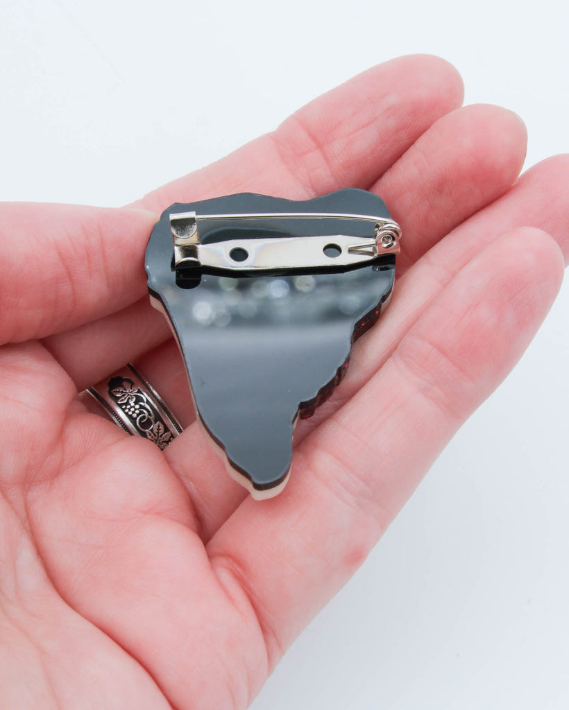 Back view of handmade acrylic steak pin showing silver safety clasp brooch backing, crafted by Electric Cat.