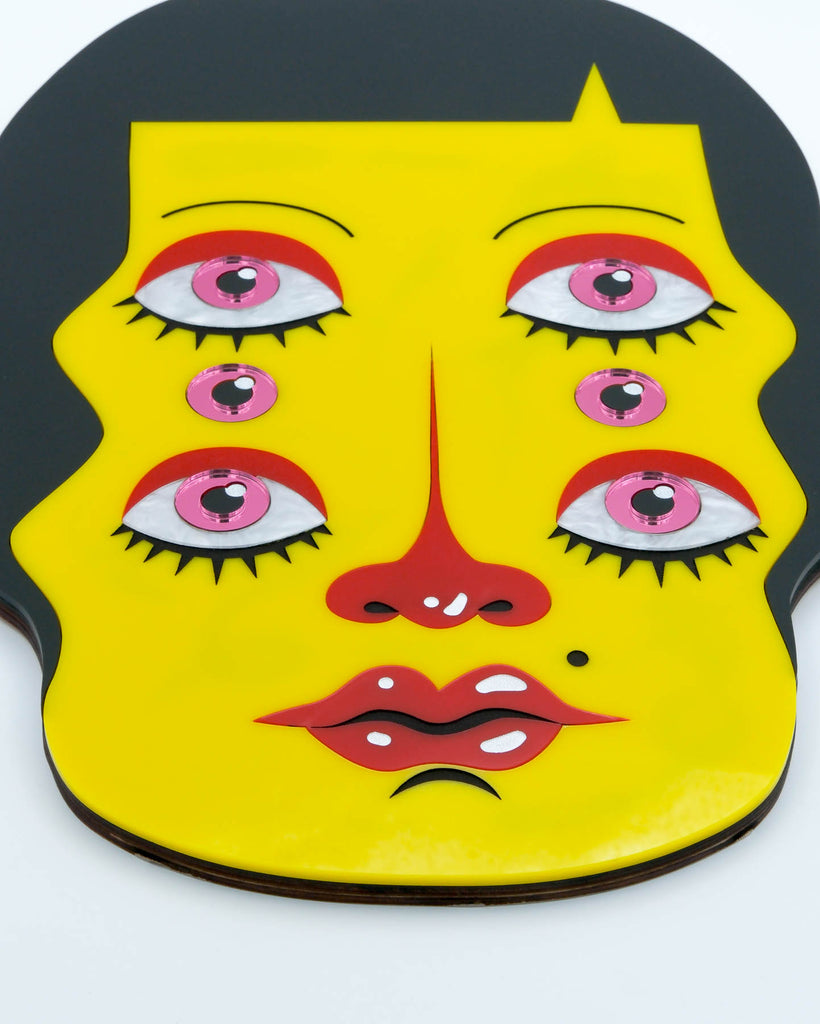 Pop surrealism portrait of a six-eyed woman with yellow skin and dark hair, laser-cut acrylic wall art by Electric Cat.