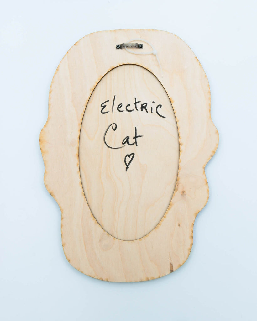 Wood backing of the Pop surrealism portrait of a six-eyed woman with yellow skin and dark hair, laser-cut acrylic wall art by Electric Cat.