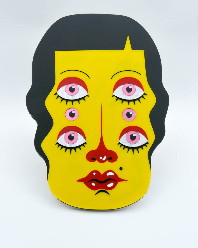 Pop surrealism portrait of a six-eyed woman with yellow skin and dark hair, laser-cut acrylic wall art by Electric Cat.